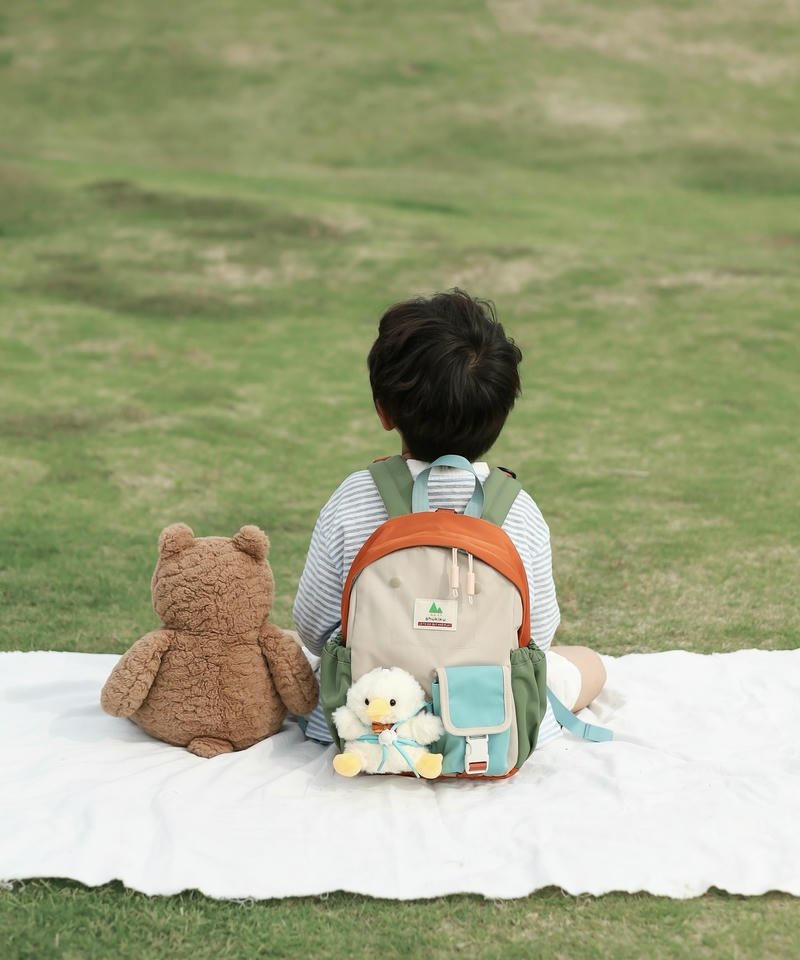 Ảnh cậu bé ngồi bãi cỏ nhìn xa xăm