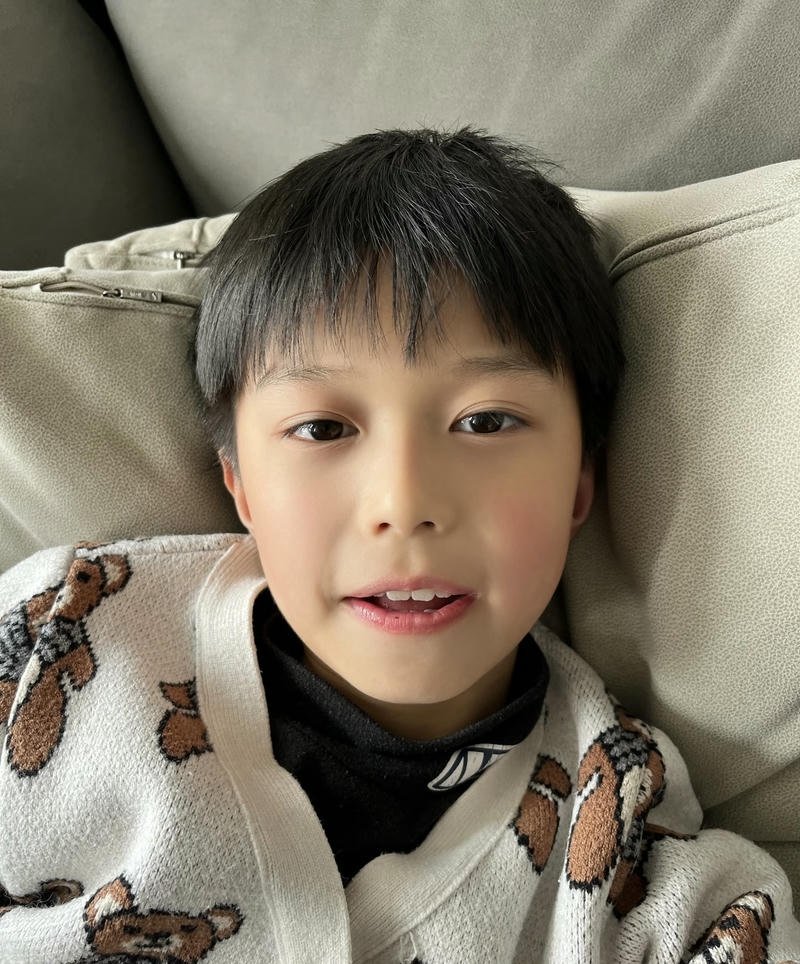 Bé trai mặc áo len nhìn máy ảnh cực dễ thương