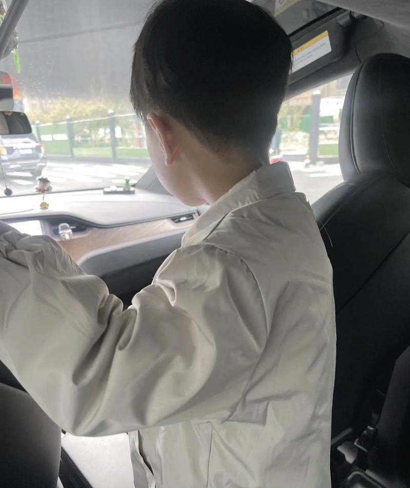 Bóng lưng cậu bé ngồi trong xe nhìn ra ngoài cửa kính