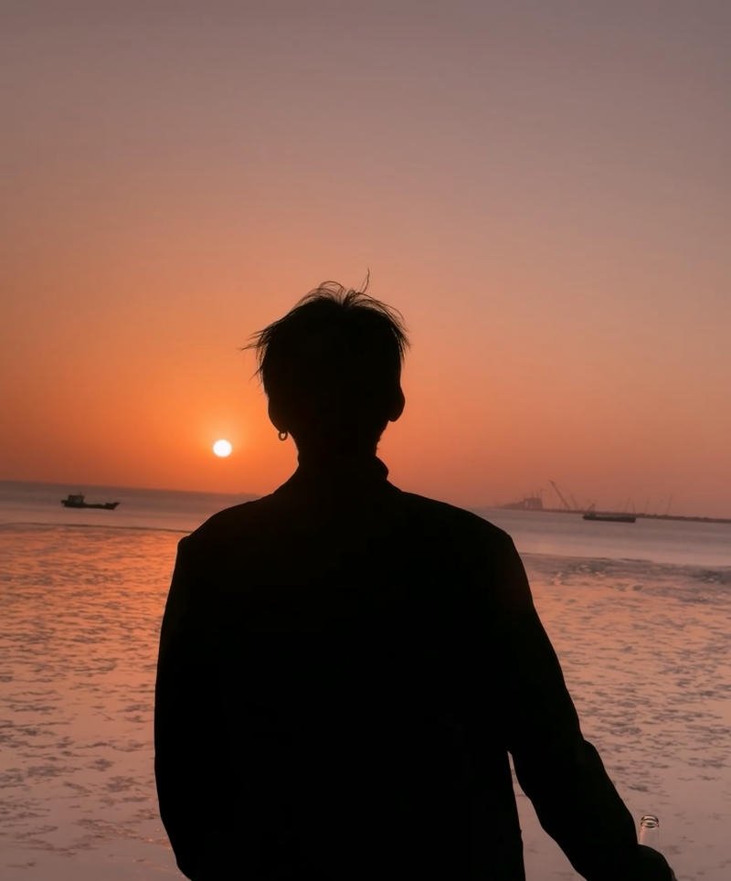 Bóng lưng chàng trai trước biển xanh chiều hoàng hôn