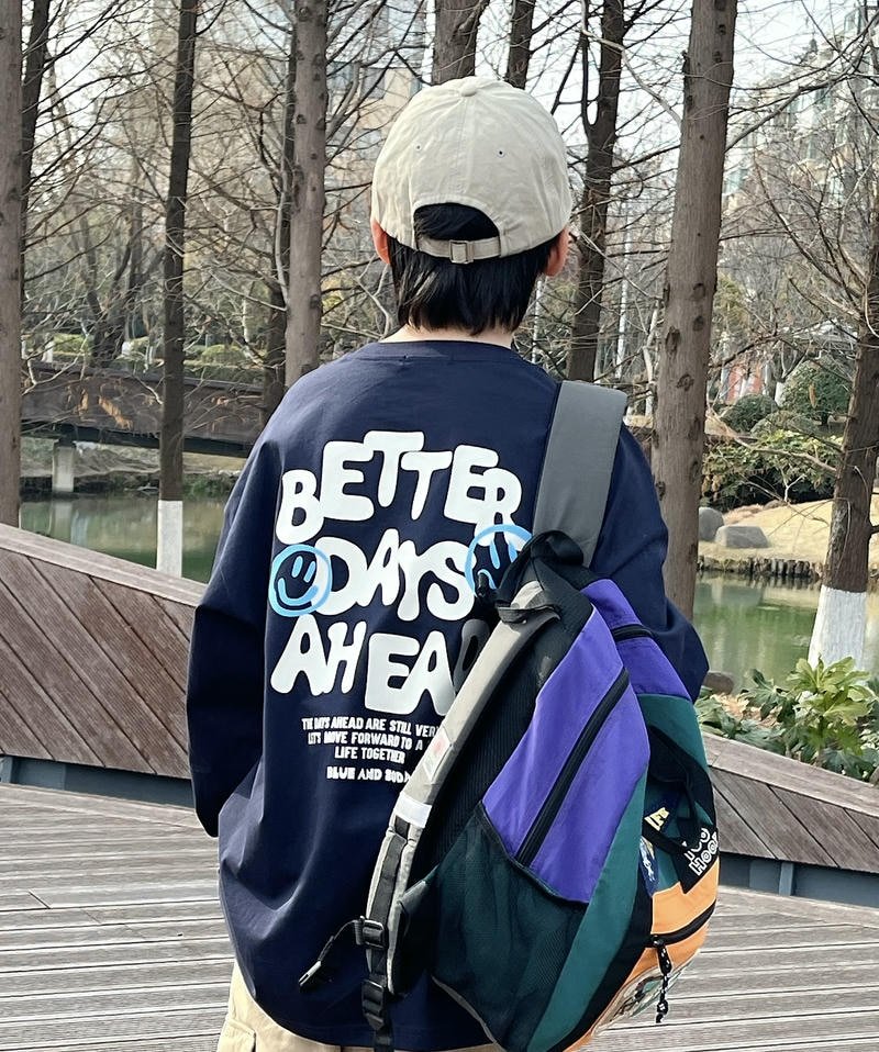 Cậu bé đứng trên cầu nhìn dòng sông từ phía sau