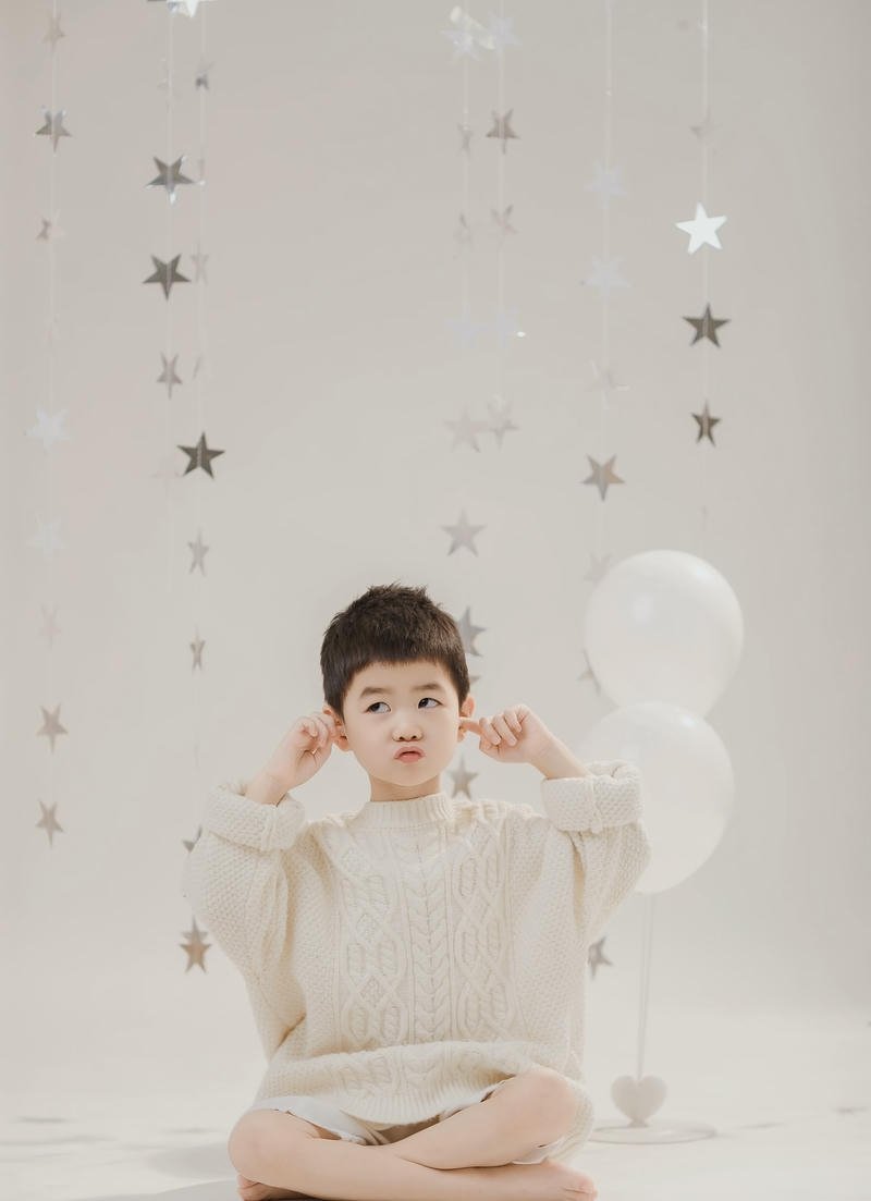 Cậu bé nhỏ mặc áo len với biểu cảm đáng yêu