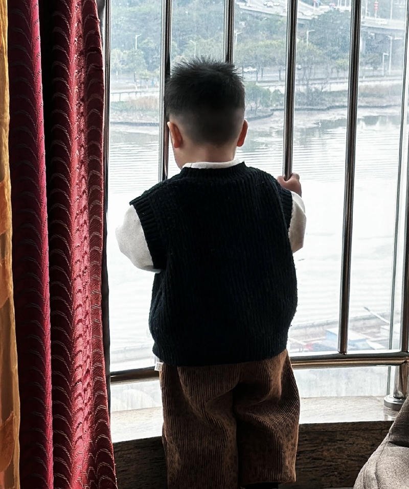 Cậu bé quay lưng nhìn qua cửa kính