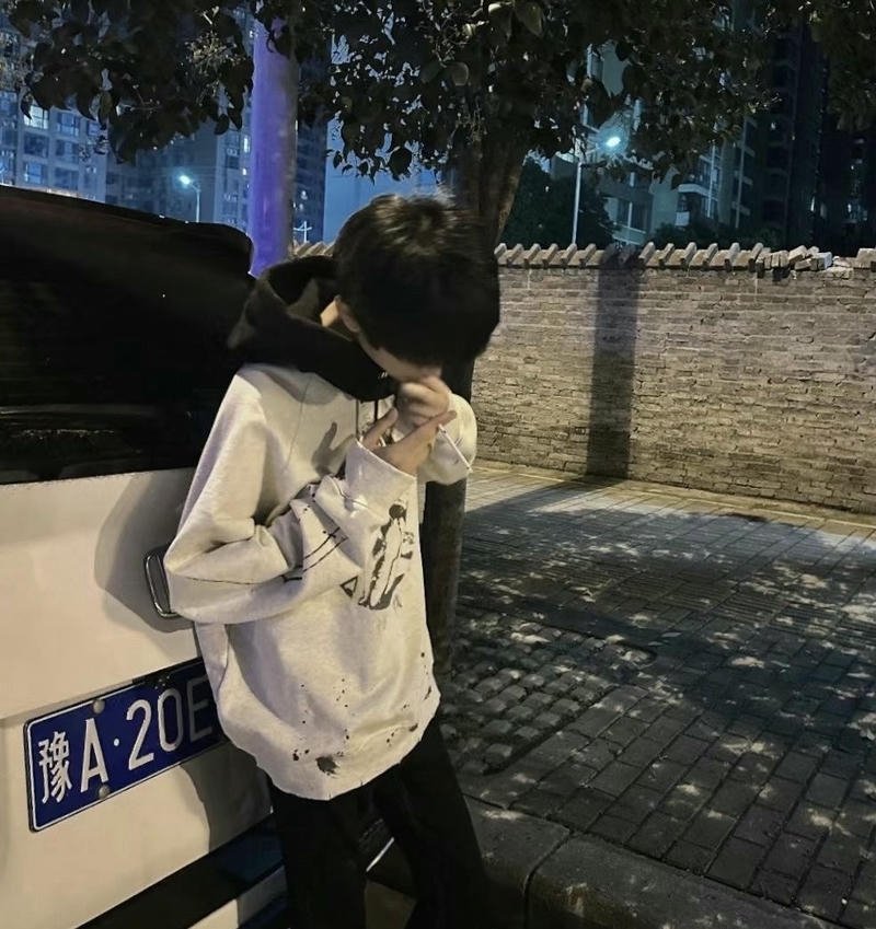 Chàng trai che mặt khi đứng một mình ngoài trời