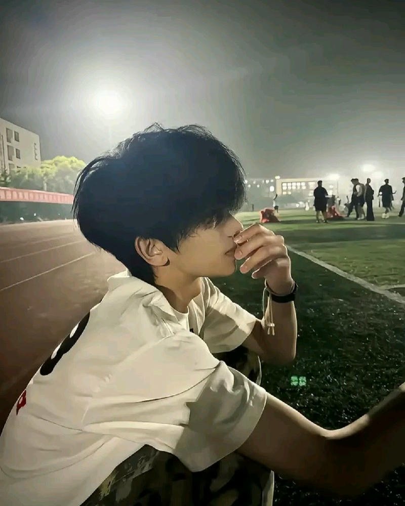 Chàng trai cúi đầu che mặt trong ánh sáng nhẹ