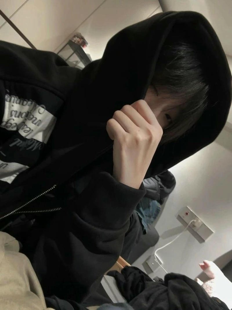 Chàng trai đứng nghiêng che mặt trước ống kính