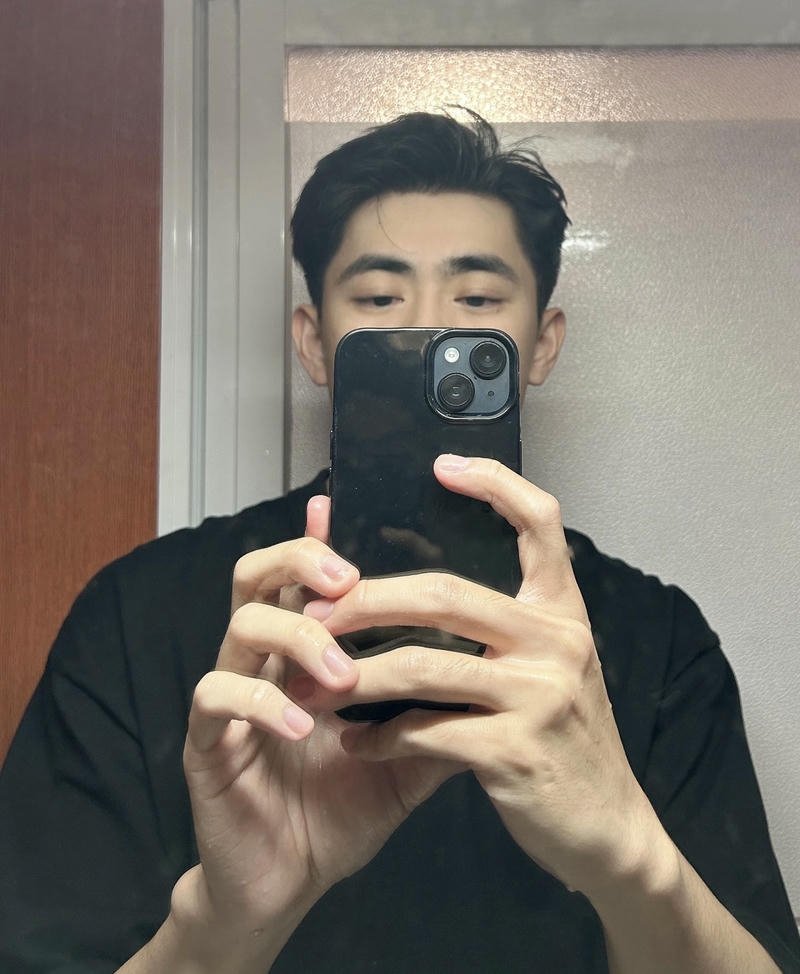 Chàng trai đứng trước gương giơ tay che mặt đầy bí ẩn