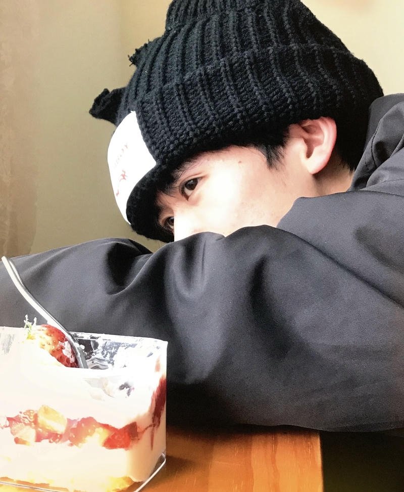 Chàng trai mặc áo khoác đen tạo dáng che mặt ngầu