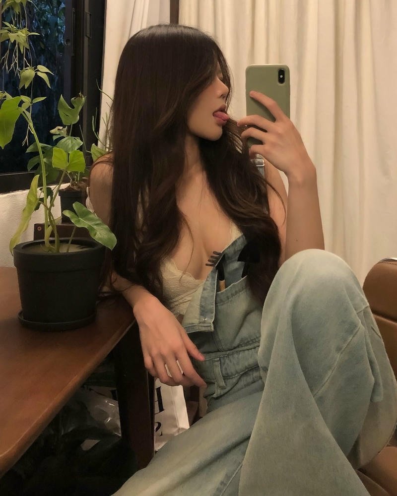 Cô gái mặc áo hai dây đứng trước biển