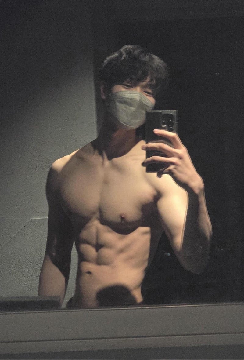 Nam thần thể hình với cơ bụng đẹp che mặt