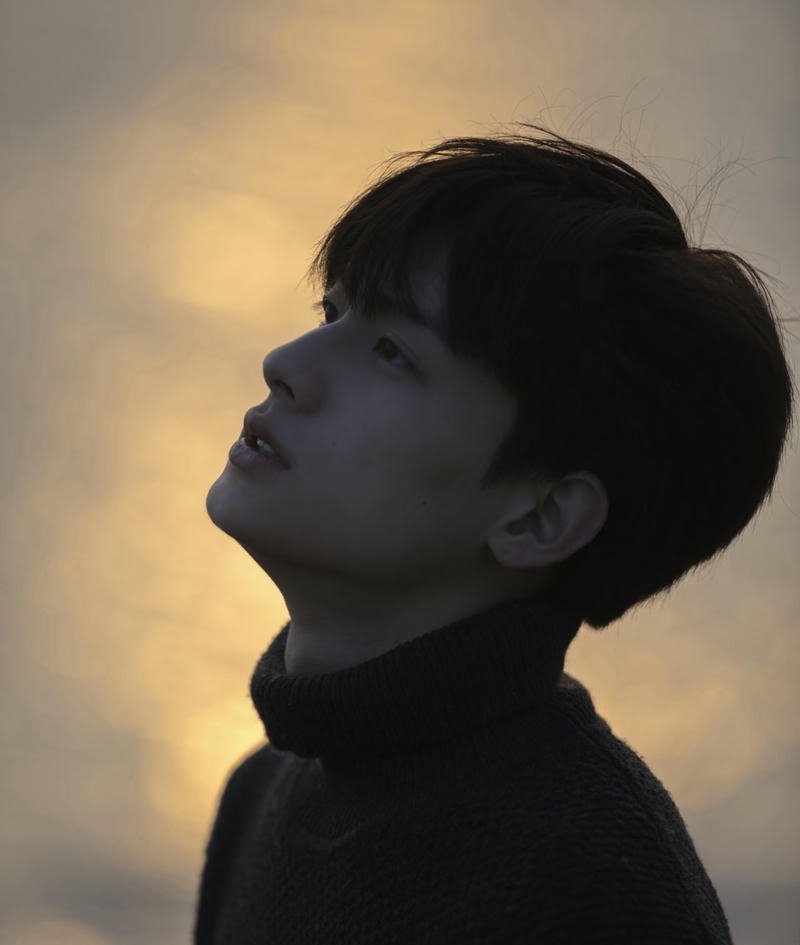 Người con trai đứng lặng trước khung cảnh hoàng hôn buồn