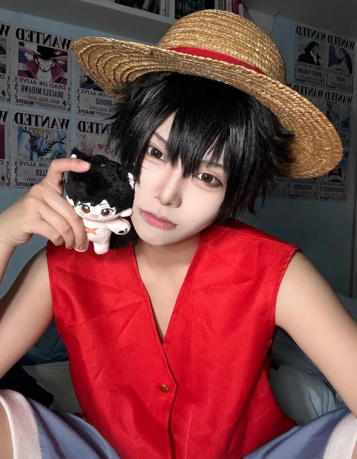 Khung cảnh Luffy cosplay ngồi với mũ rơm đặc trưng