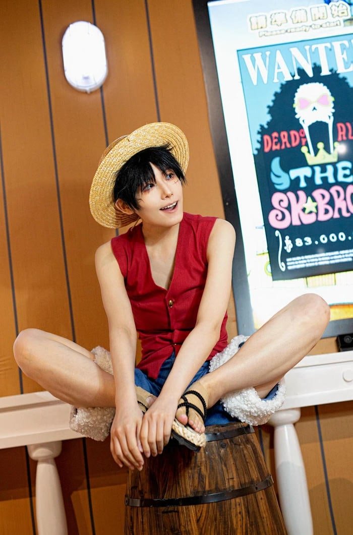 Luffy ngồi áo đỏ trong không gian phòng tạo dáng đẹp